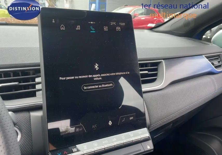 Vue intérieure du tableau de bord du Renault Captur bleu Iron Metal, avec écran tactile central vertical allumé.