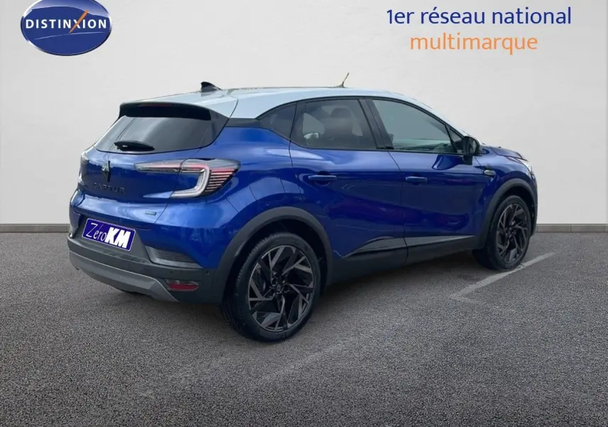 Renault Captur E-Tech hybride bleu Iron Metal avec toit gris, vu de trois quarts arrière côté droit.