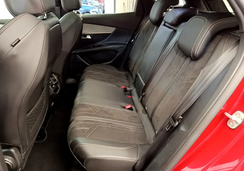 Vue intérieure côté droit des sièges arrière en cuir et alcantara noirs du Peugeot 3008 GT rouge de 2021 avec surpiqûres contrastées.