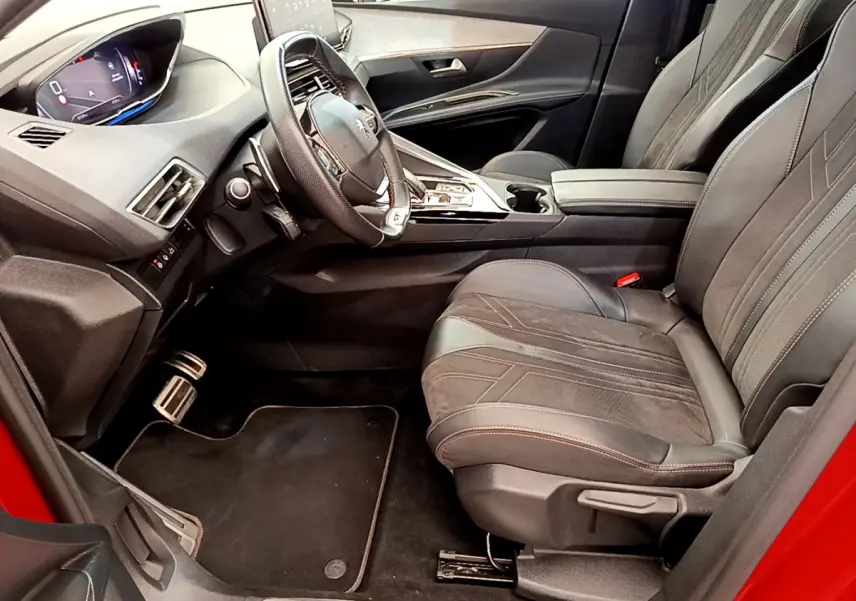 Intérieur côté conducteur du Peugeot 3008 GT rouge 2021, avec sièges cuir et tableau de bord numérique.