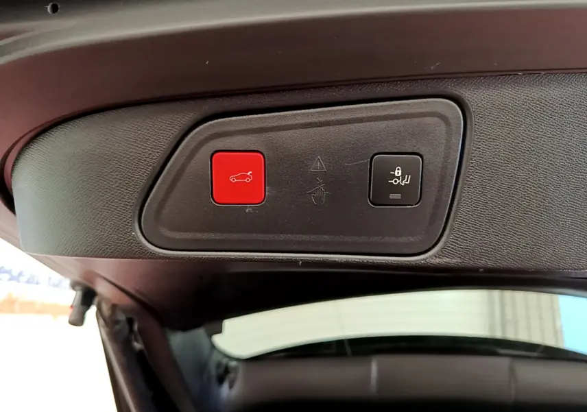 Boutons de commande du hayon électrique et verrouillage sur la partie intérieure du coffre du Peugeot 3008 rouge.