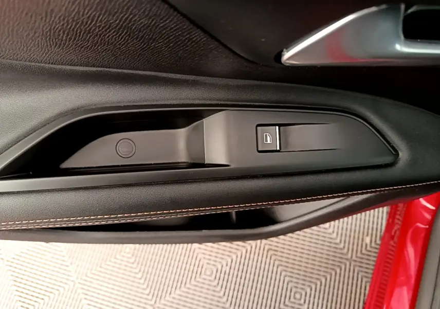 Poignée intérieure côté gauche avec bouton de verrouillage sur porte rouge du Peugeot 3008 GT 2021.