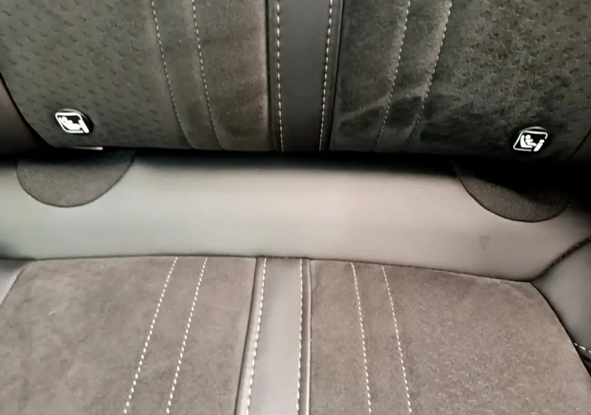 Gros plan sur la banquette arrière en tissu gris avec surpiqûres contrastantes et fixations Isofix visibles.
