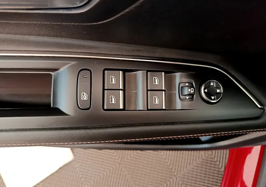 Gros plan sur les commandes de vitres et rétroviseurs côté conducteur du PEUGEOT 3008 rouge 2021.
