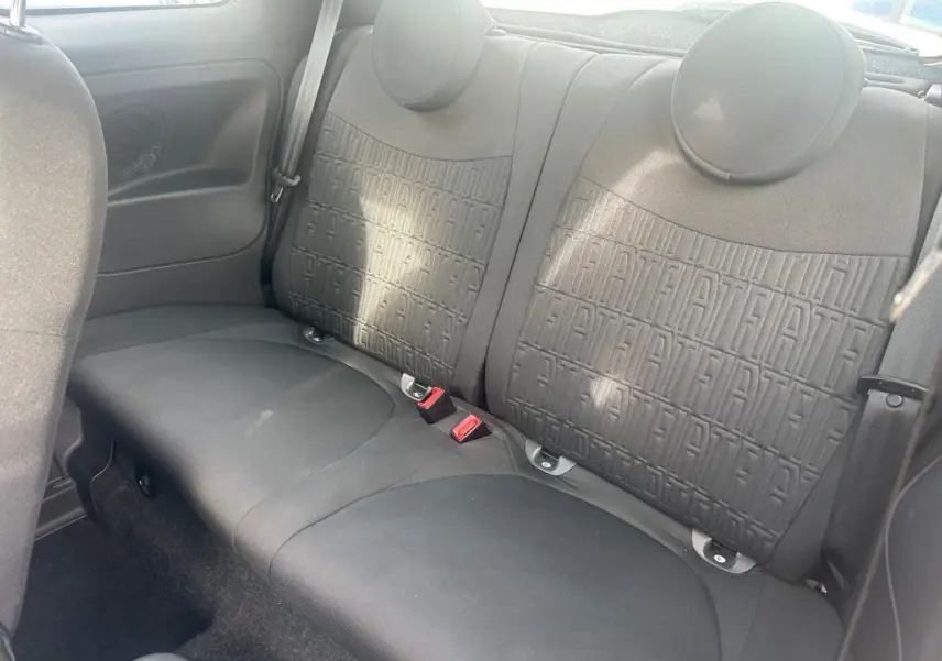 Vue intérieure sur les sièges arrière noirs de la FIAT 500 2023 avec motifs FIAT embossés sur le dossier.