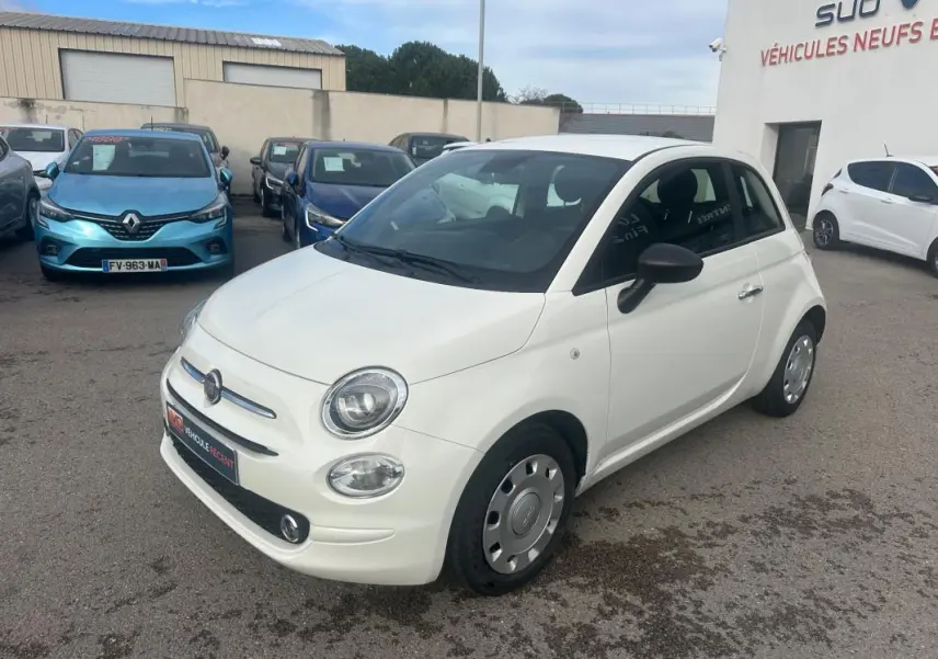 Vue 3/4 avant droite d'une FIAT 500 blanche 2023, avec ses phares ronds caractéristiques et jantes acier d'origine.
