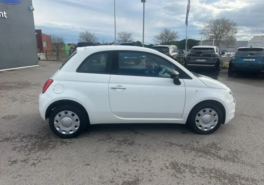 Vue de profil côté gauche d'une FIAT 500 blanche de 2023, compacte avec jantes acier et rétroviseurs noirs.
