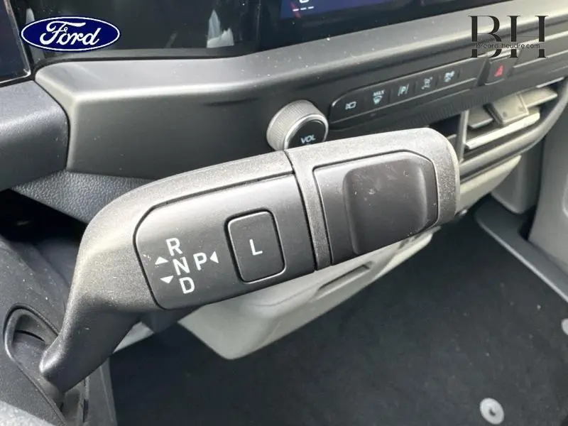 Gros plan sur le levier de boîte automatique du Ford Transit Custom gris lunaire, avec tableau de bord en arrière-plan.