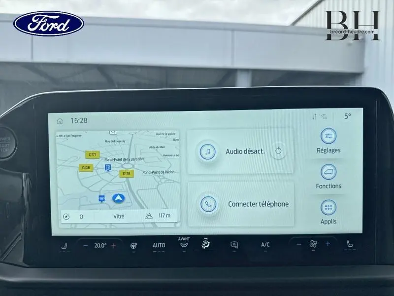 Écran tactile central du Ford Transit Custom hybride, affichant navigation et options multimédia, vue intérieure avant.