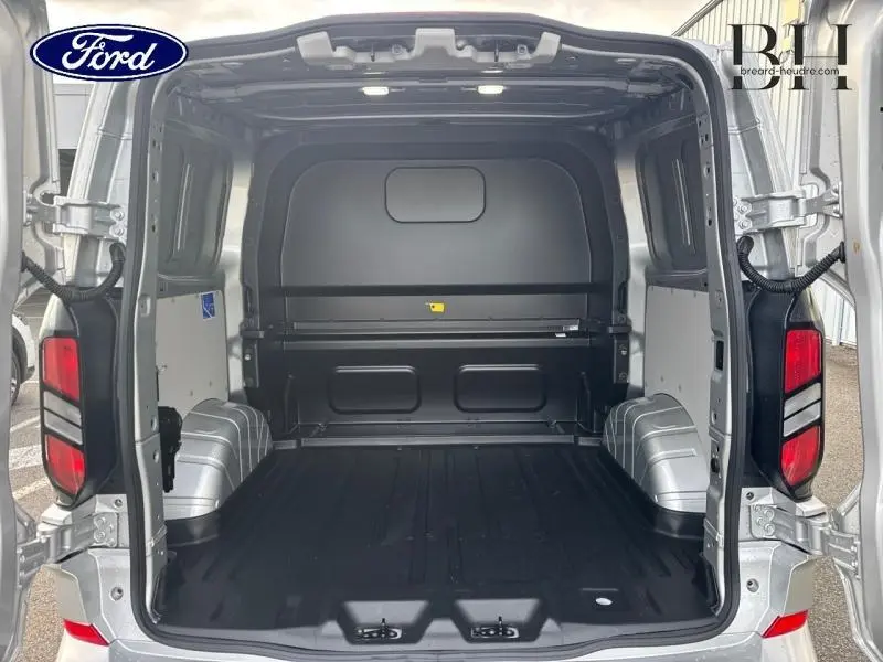 Vue arrière ouverte du Ford Transit Custom Fourgon gris lunaire métallisé montrant l'espace de chargement vide et le plancher noir.