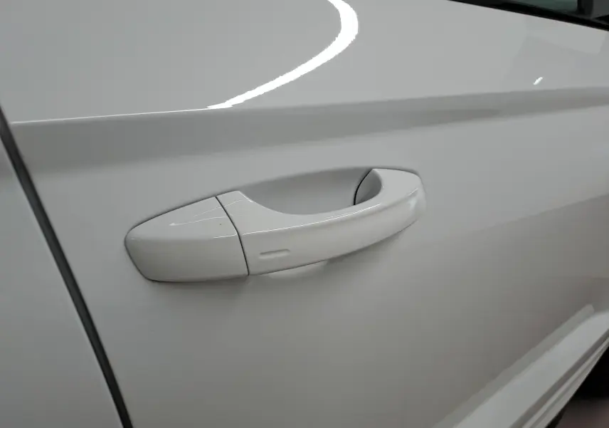 Poignée de porte blanche lune côté gauche du Skoda Karoq 1.5 TSI 150 DSG7 Sportline 2025, vue en gros plan.