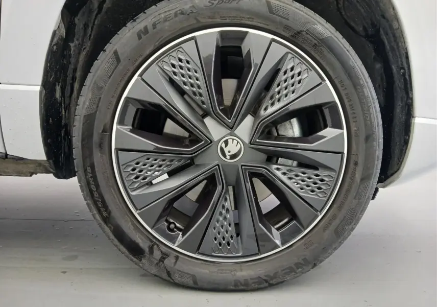 Gros plan sur la roue avant droite du Skoda Karoq Blanc Lune 2025 avec jante alliage Sportline au design moderne.