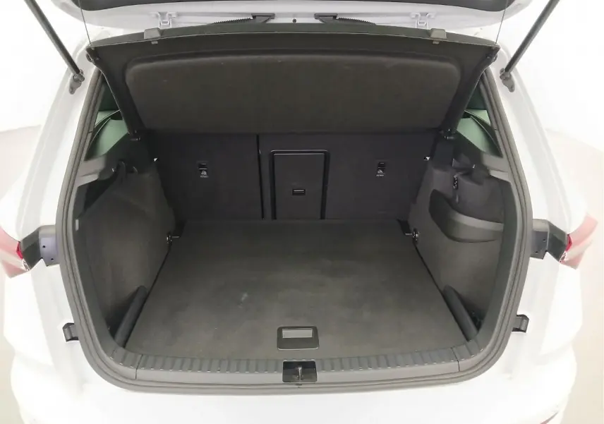 Coffre ouvert vu de l'arrière d'un Skoda Karoq Blanc Lune 2025, version 1.5 TSI 150 DSG7 Sportline, espace de chargement vide.