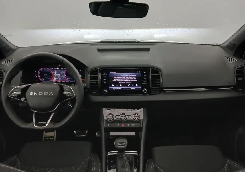 Vue intérieure frontale du tableau de bord et volant SKODA KAROQ 1.5 TSI 150 DSG7 SPORTLINE 2025, ambiance noire moderne.