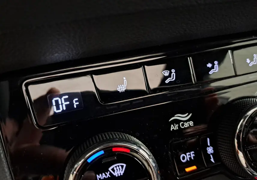 Détail du tableau de bord du Skoda Karoq 2025 blanc lune, montrant les commandes de climatisation et sièges chauffants.