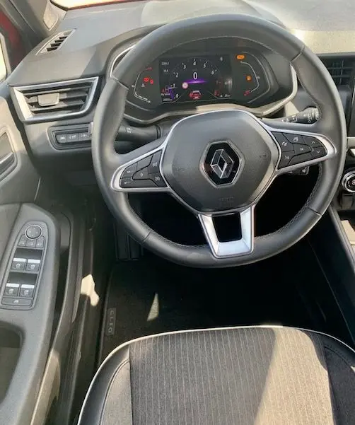 Vue intérieure centrée sur le volant multifonction de la Renault Clio V 1.0 TCE 90CH Intens X-Tronic avec tableau de bord numérique.