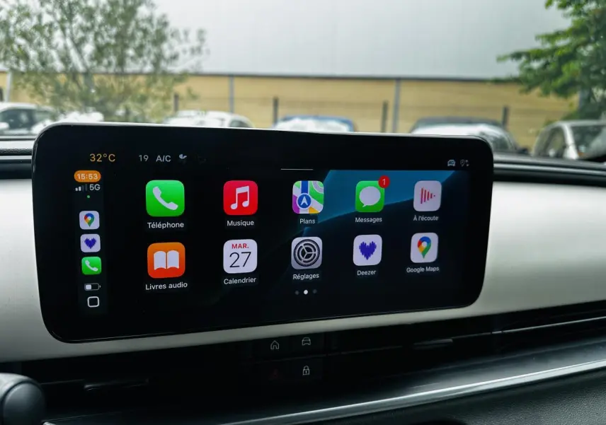 Écran tactile central affichant Apple CarPlay dans l'habitacle du FIAT 600 bleu clair, vue de face.