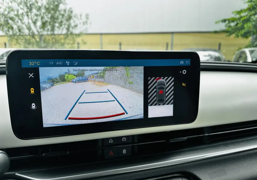 Écran central affichant la caméra de recul et l’aide au stationnement dans l’habitacle ivoire du Fiat 600 bleu clair.