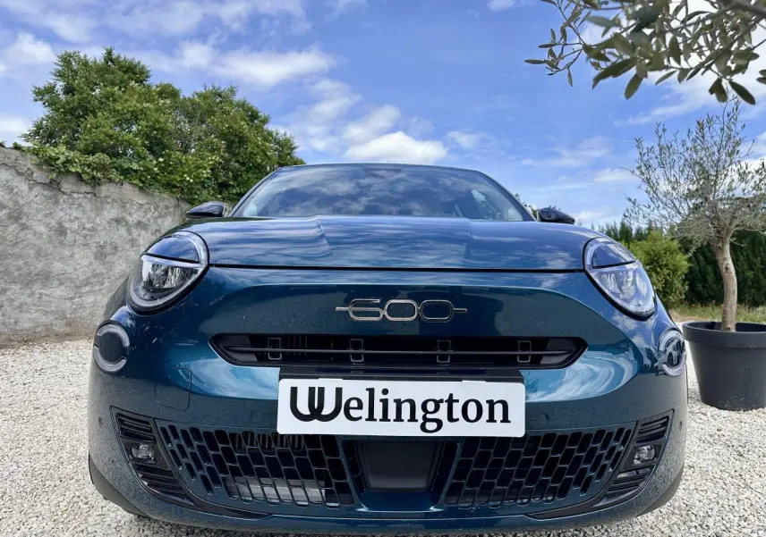 Vue avant rapprochée du FIAT 600 bleu clair 2024 avec logo 600 centré et phares ronds LED distinctifs.