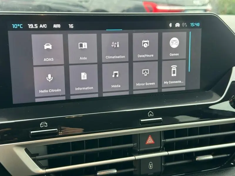 Écran tactile central du tableau de bord de la Citroën C4 X gris Mercury, affichant les options de climatisation et multimédia.