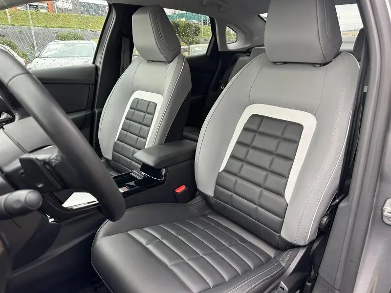 Vue intérieure rapprochée des sièges avant en cuir bicolore gris et noir du Citroën C4 X 2025.