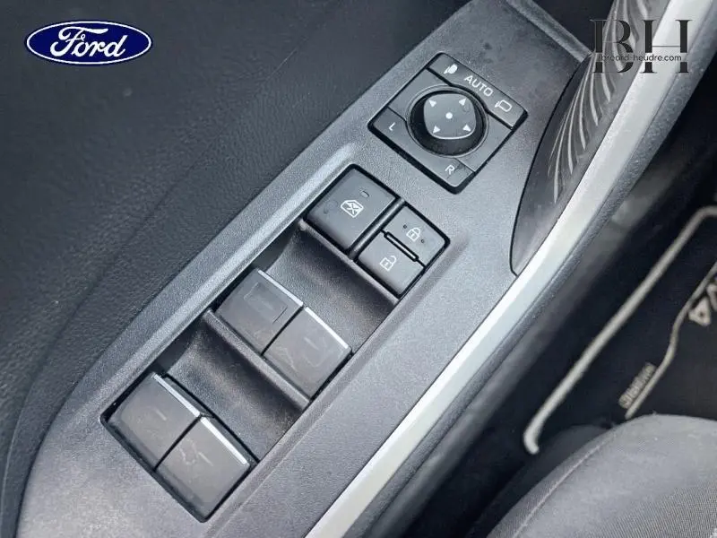 Gros plan sur les commandes de lève-vitres et rétroviseurs côté conducteur d'un Toyota RAV4 noir, intérieur tissu sport noir.