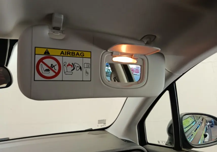 Détail intérieur du pare-soleil côté conducteur avec miroir éclairé dans une Fiat 500X blanche de 2020.