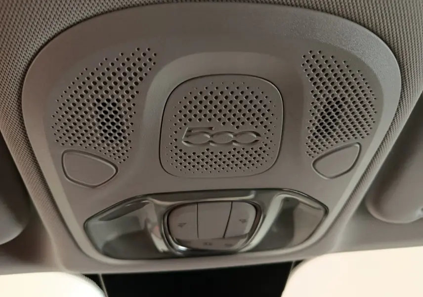 Plafonnier intérieur gris avec logo 500 et commandes d'éclairage, vue en contre-plongée dans une Fiat 500X blanche.