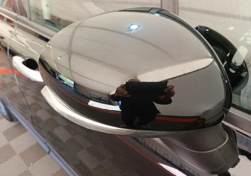 Rétroviseur extérieur noir brillant côté conducteur d'une FIAT 500X 2020, reflet de l'environnement intérieur visible.