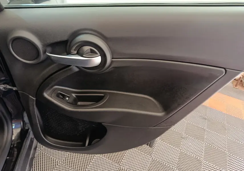 Intérieur côté droit de porte FIAT 500X blanc, avec poignée argentée et commande de vitre noire.