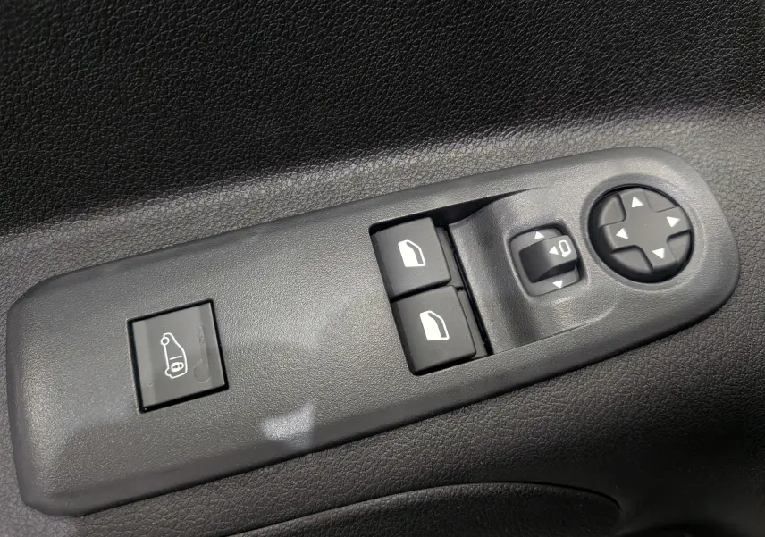 Gros plan sur les commandes de réglage des rétroviseurs et des vitres côté conducteur du Citroën Berlingo blanc 2025.
