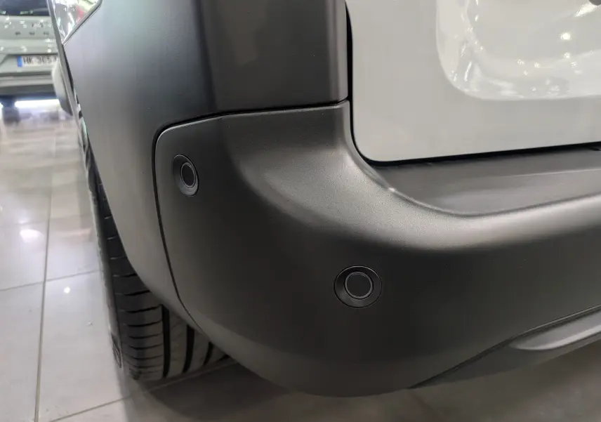 Gros plan sur le pare-chocs arrière noir du Citroën Berlingo blanc 2025, avec capteurs de stationnement visibles.