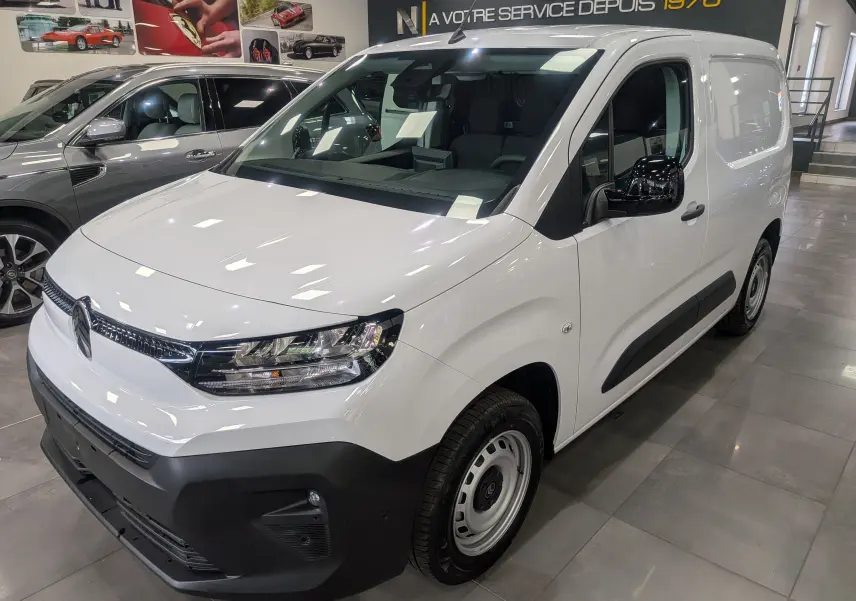 Vue 3/4 avant droite du Citroën Berlingo Van blanc 2025 avec pare-chocs noir et jantes acier en showroom.