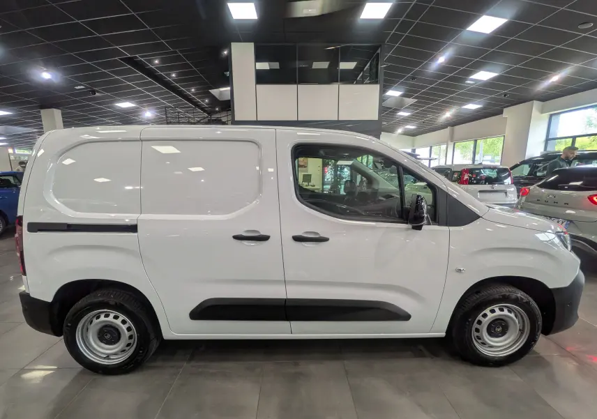 Vue de profil côté droit d'un Citroën Berlingo Van blanc 2025 avec protections noires et jantes acier en showroom.