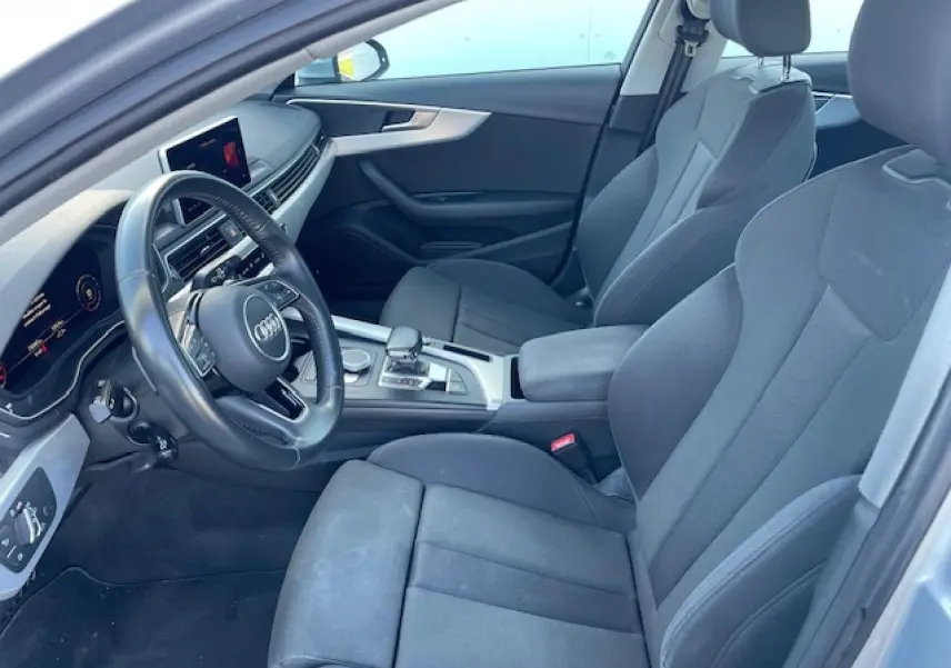 Intérieur avant de l'Audi A4 2019 en tissu gris avec volant multifonction et console centrale argentée vue côté conducteur.