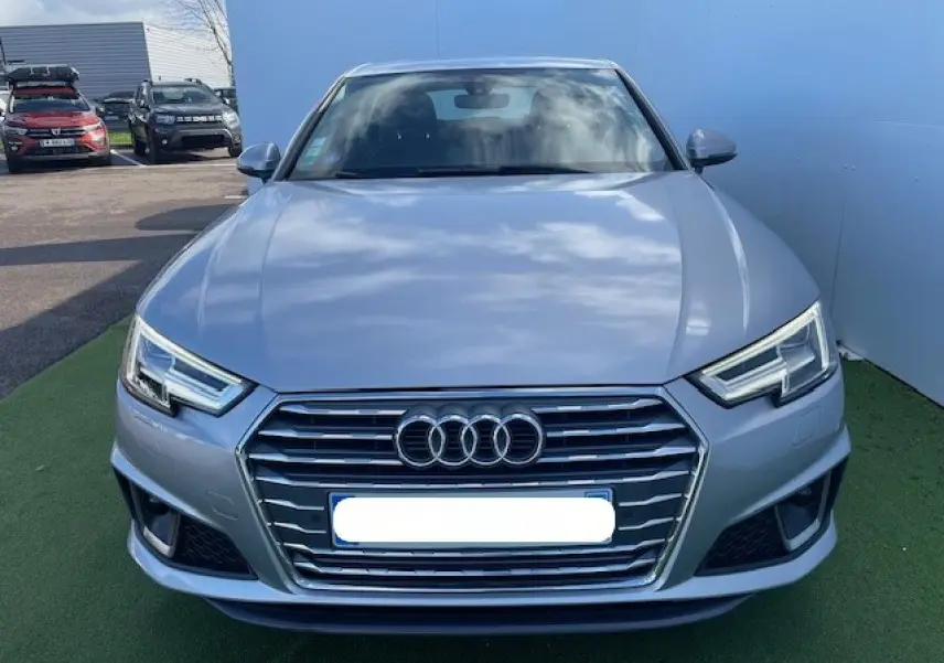 Vue frontale d'une Audi A4 argent fleuret métal 2019 avec calandre hexagonale et phares LED anguleux.