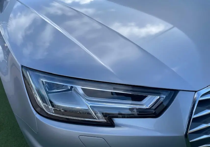 Gros plan sur le phare avant droit d'une Audi A4 2019 argent fleuret métal avec calandre partielle visible.