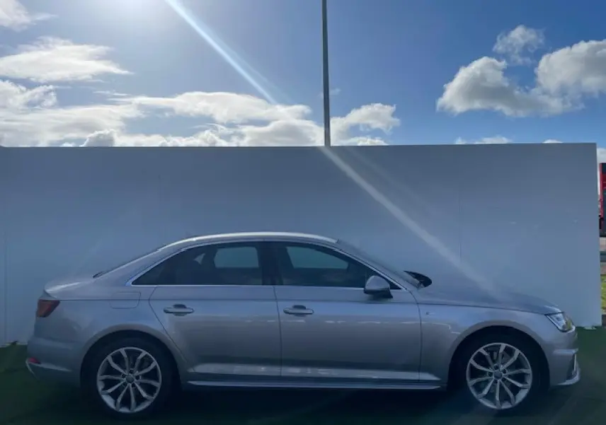 Audi A4 V 35 TFSI 2019 en profil côté gauche, finition argent métallisé avec jantes alliage 5 branches en Y.