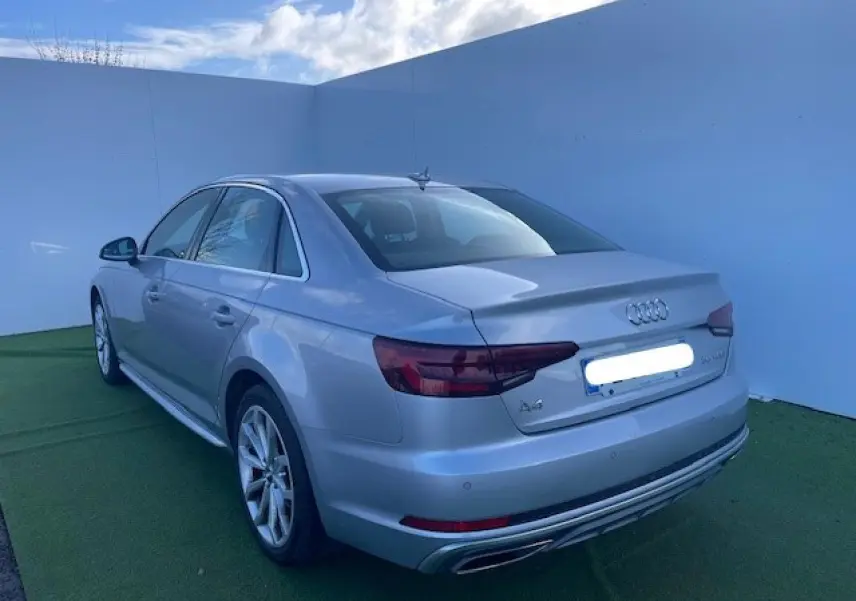 Audi A4 argent fleuret métal vue 3/4 arrière côté gauche avec jantes 5 branches et feux arrière LED