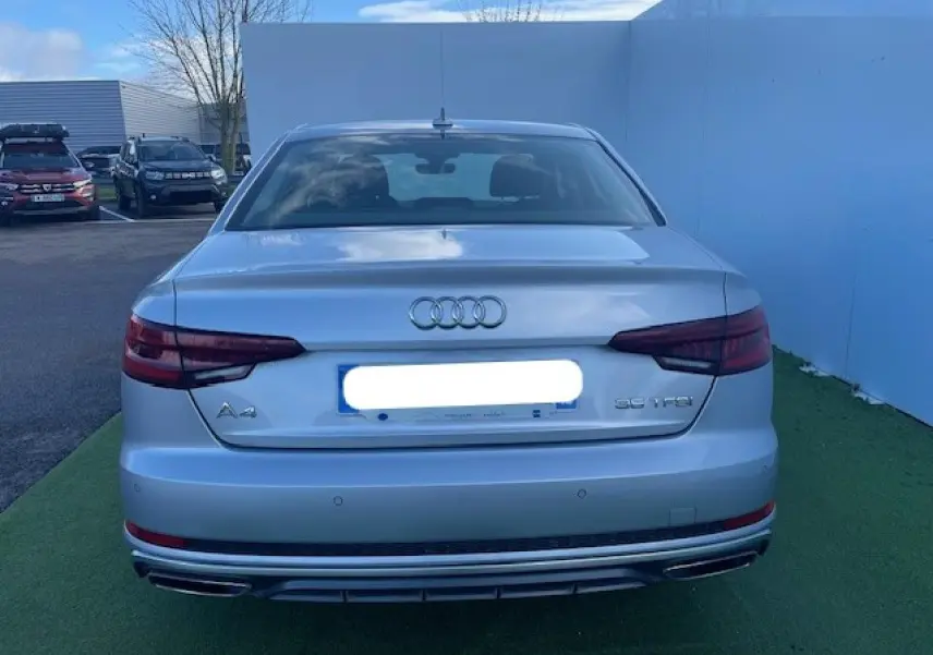 Vue arrière d'une Audi A4 argent fleuret métal avec feux arrière LED et double sortie d'échappement chromée.