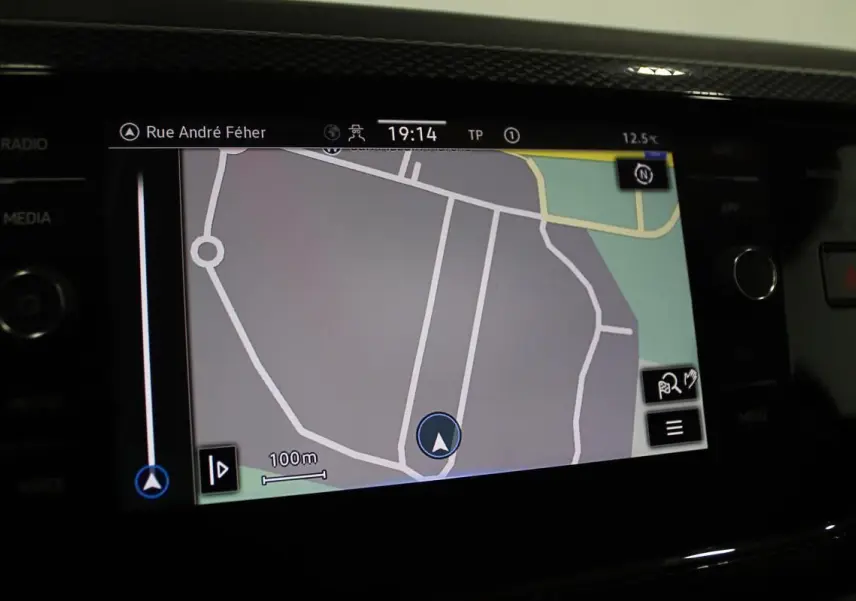 Écran de navigation GPS allumé dans l'habitacle d'une Volkswagen Polo noire, affichant une carte routière détaillée.