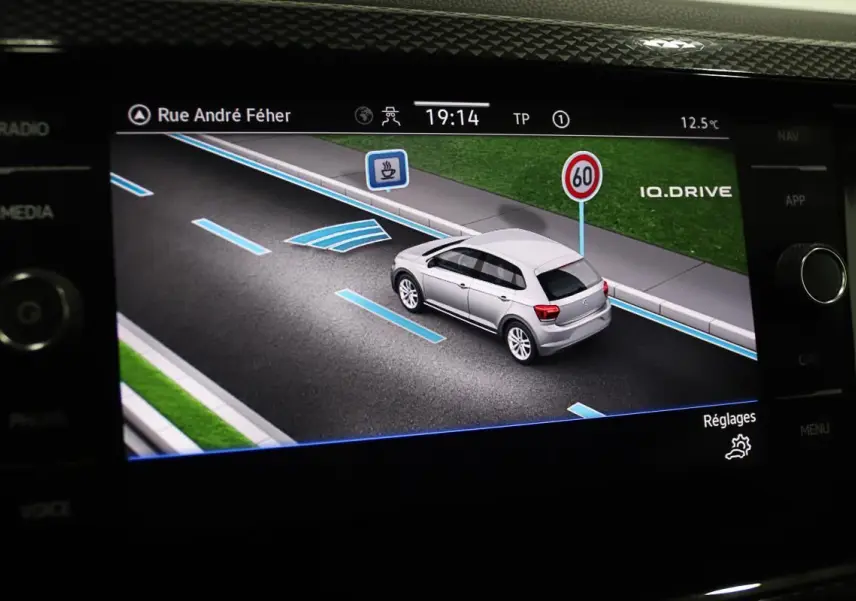 Affichage du Virtual Cockpit montrant une Volkswagen Polo noire en simulation de conduite avec indications de voie et limitation à 60 km/h