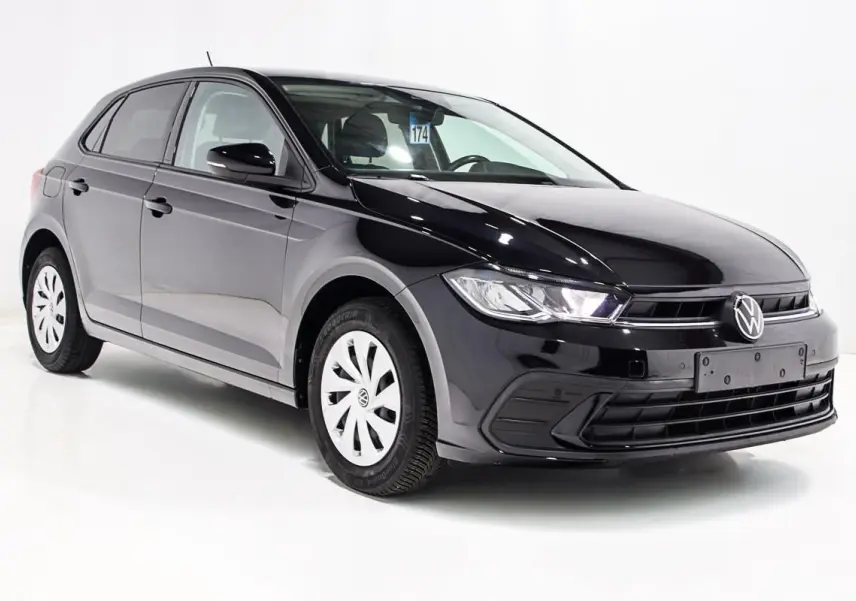 Volkswagen Polo noire vue en 3/4 avant droit, avec jantes blanches et calandre épurée sur fond blanc.