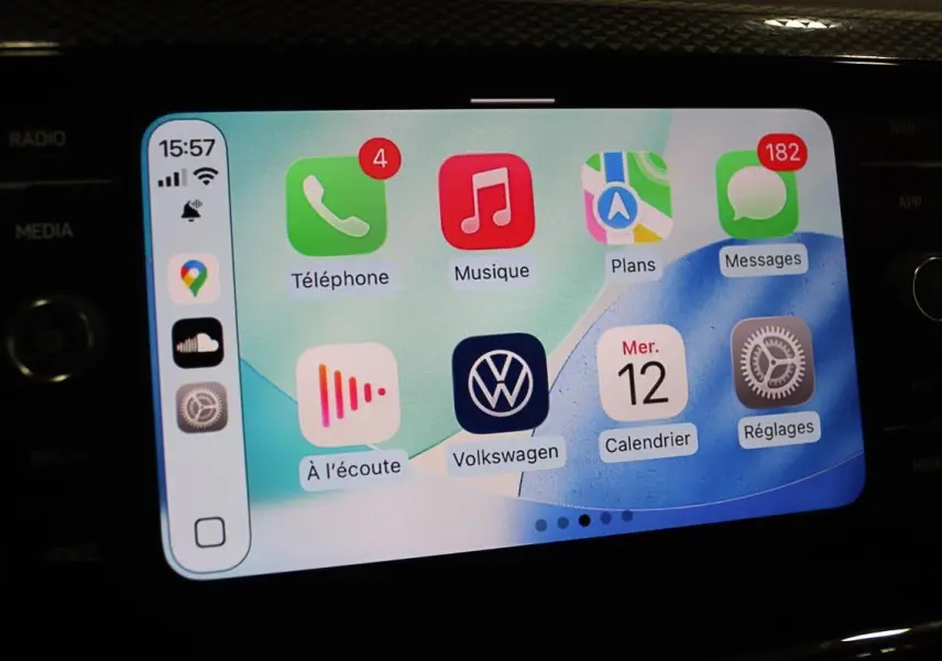 Écran tactile du système Apple CarPlay dans une Volkswagen Polo noire, affichant les applications de navigation et communication.