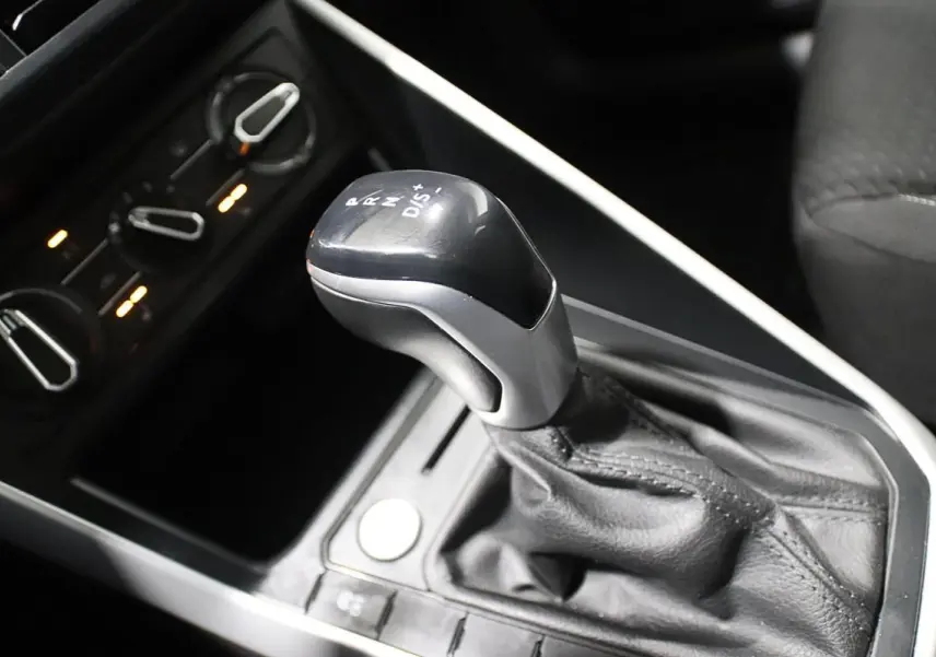 Le levier de vitesse automatique noir et argenté de la Volkswagen Polo 1.0 TSI 95 DSG, avec commandes de climatisation en arrière-plan.