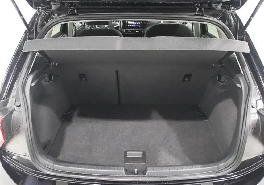 Coffre ouvert d'une Volkswagen Polo noire 2022, vue arrière montrant l'espace de chargement vide et l'intérieur sombre.