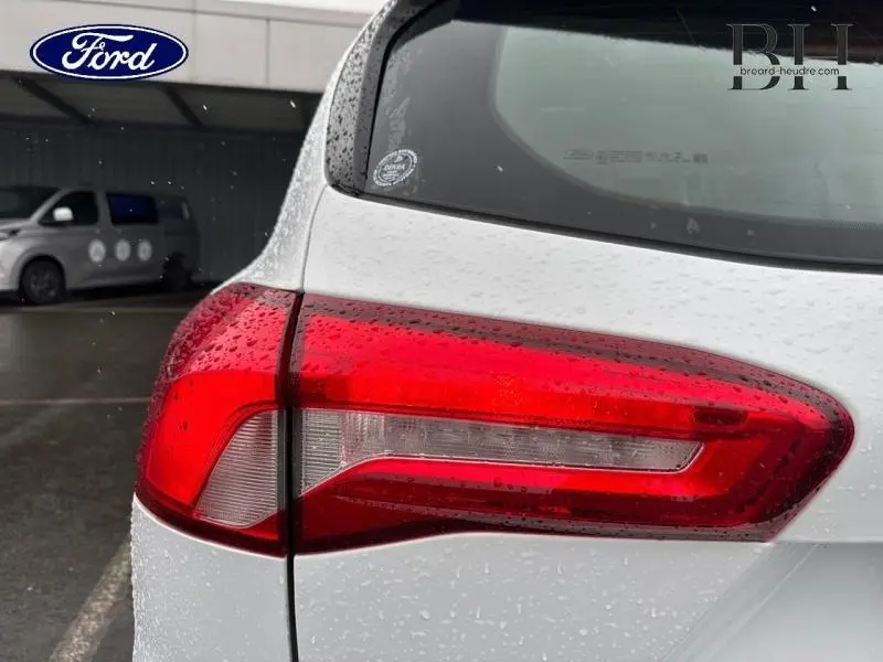 Gros plan sur le feu arrière droit d'une Ford Focus SW 2020 blanc glacier avec gouttes de pluie visibles.