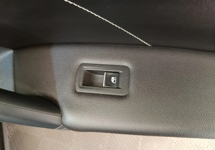 Bouton de commande de vitre électrique sur la porte intérieure en cuir noir du Volkswagen Tiguan 2023 hybride.