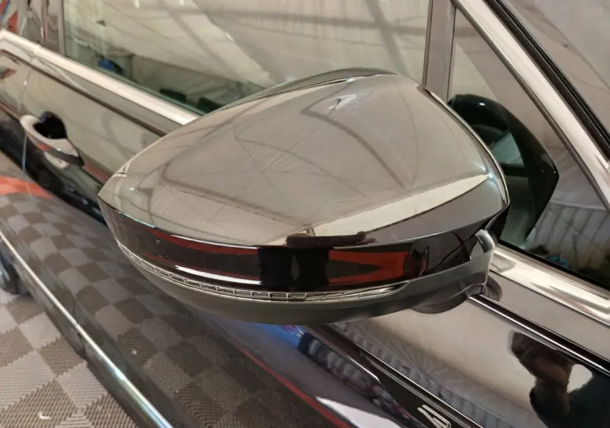 Rétroviseur droit noir brillant avec clignotant intégré sur Volkswagen Tiguan 1.4 EHYBRID 2023, vue rapprochée.