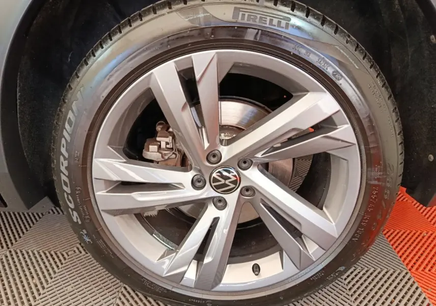 Gros plan sur la roue avant droite du Volkswagen Tiguan noir, avec jante alliage et pneu Pirelli Scorpion.
